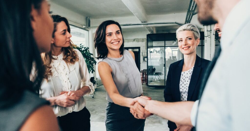 Professional handshake in office setting for kahuna and infor partnership